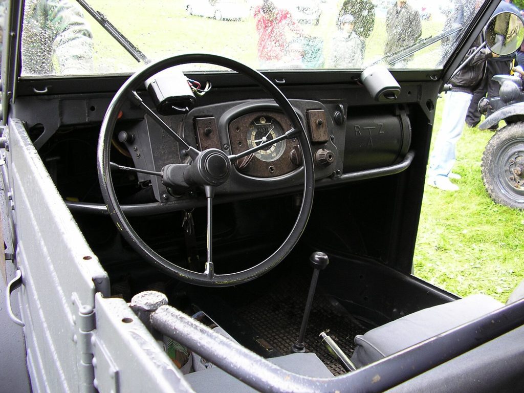 Innenraum eines VW Typ 82 Kübelwagen mit einfachen Sitzen und Stauraum für militärische Ausrüstung.